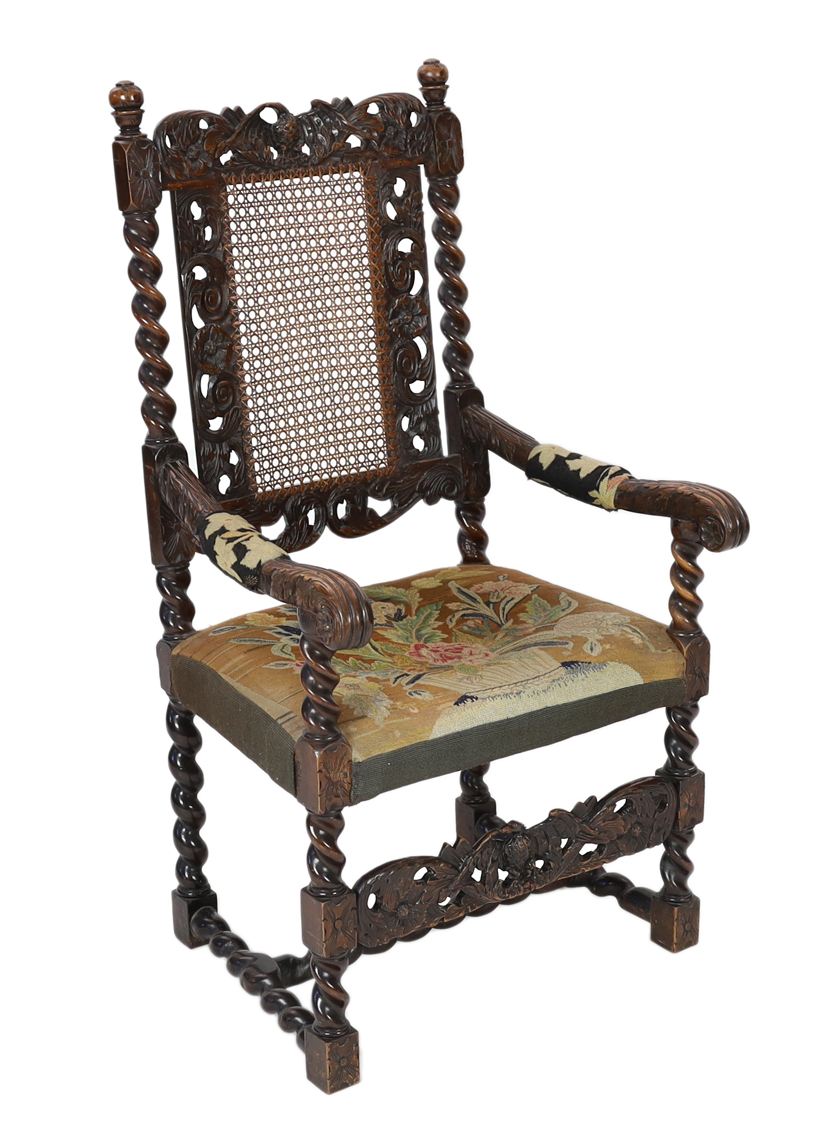A Charles II carved walnut caned back elbow chair, with a contemporary needlework upholstered seat, c.1670, width 63cm, height 116cm, Please note this lot attracts an additional import tax of 5% on the hammer price